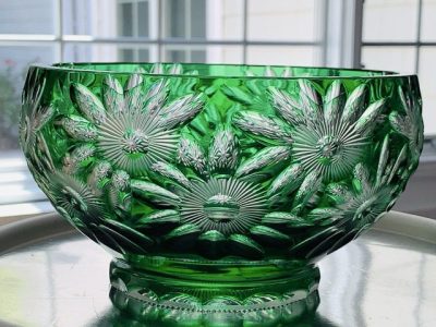 Intricately carved green glass bowl with floral patterns.