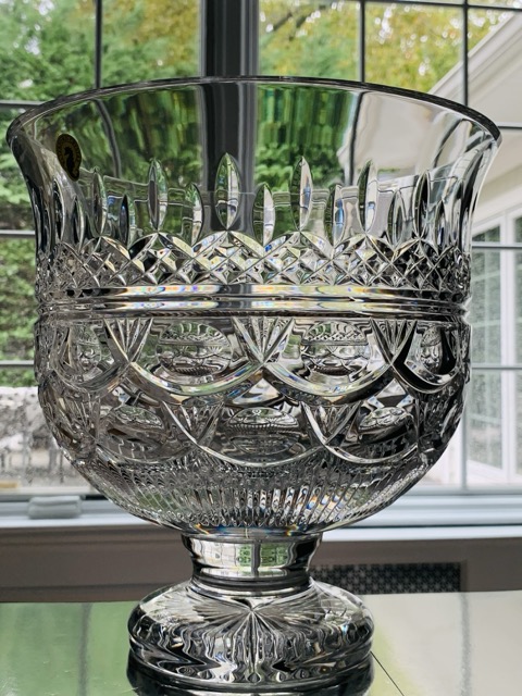 Crystal wine glasses on windowsill with sunlight.